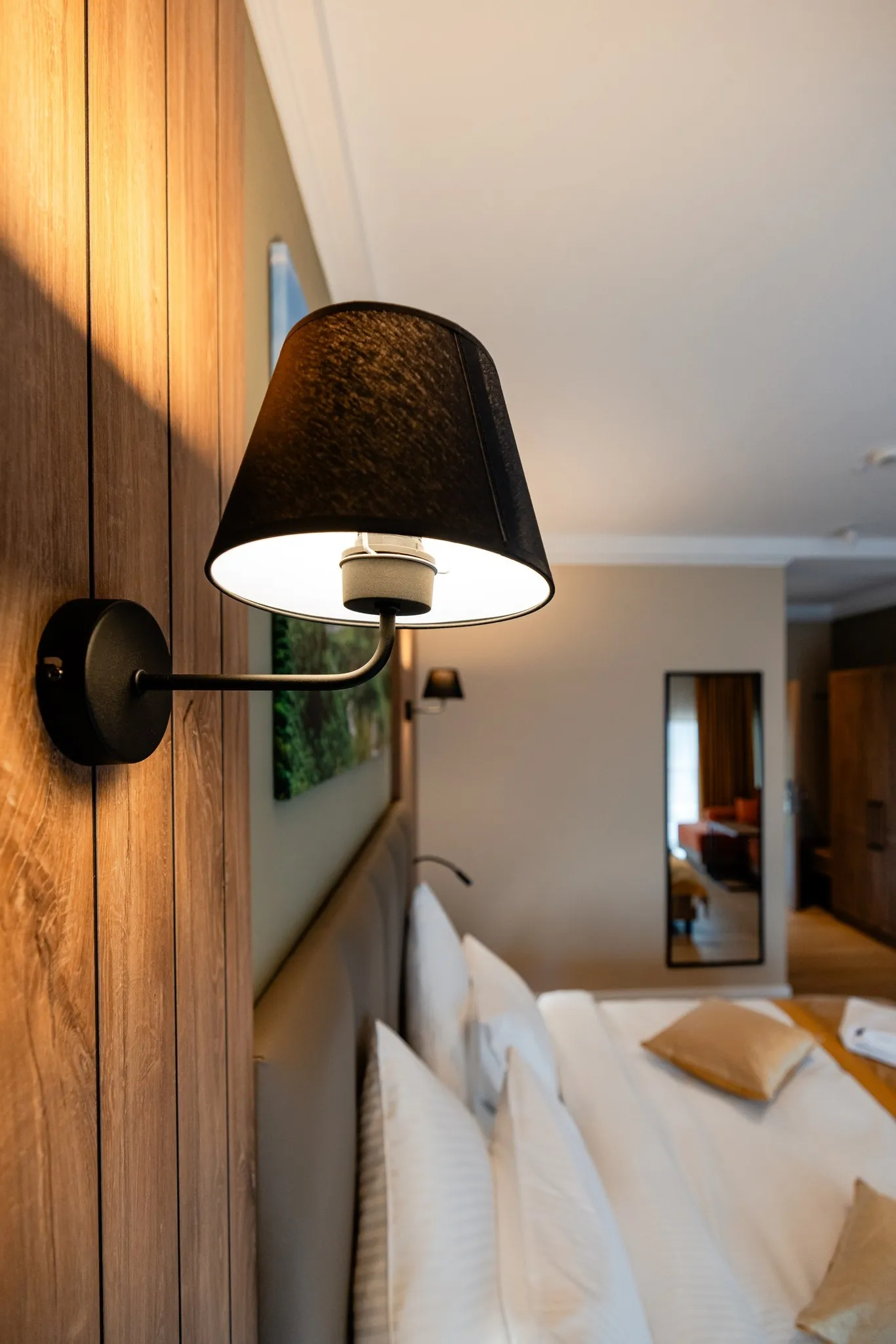 Detaliu camera - lampa perete, pat in fundal